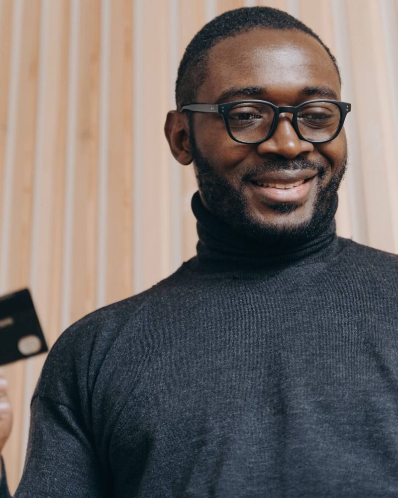 cheerful-african-american-businessman-holding-credit-card-and-smartphone-for-shopping-in-internet-1.jpg